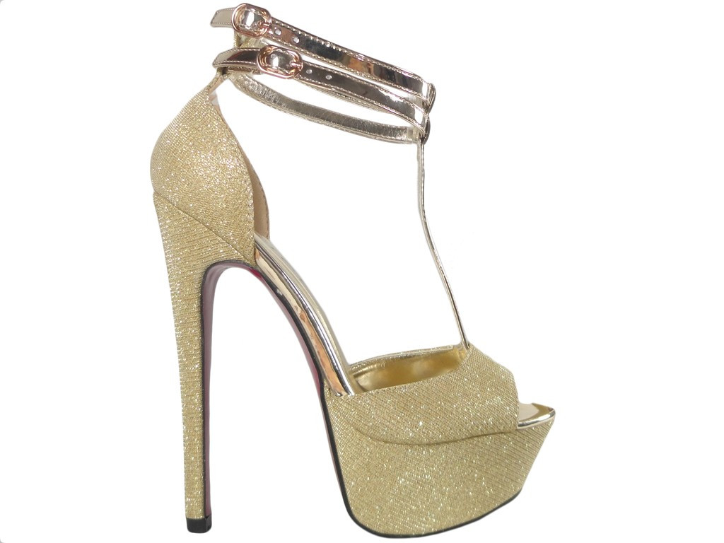 Goldene Anstecknadeln auf einem Podest mit einem gewürfelten glitzernden Gürtel - 1