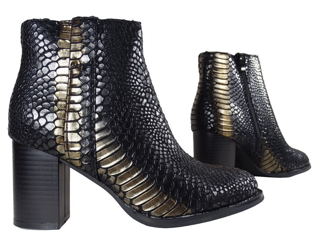Bottes de femme à écailles noires et dorées sur un poteau - 3