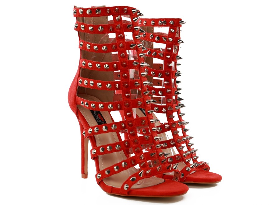 Red gladiator sandals with stiletto heels, spikes, and studs